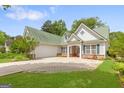 Inviting home features a two-car garage and a well-manicured lawn at 2340 Landrum Ct, Lawrenceville, GA 30043