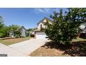 Charming two-story home with a stone veneer and a well-manicured front yard under a clear blue sky at 2805 Topaz Rd, Riverdale, GA 30296