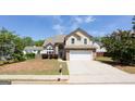 Charming two-story home with a stone veneer and a well-manicured front yard under a clear blue sky at 2805 Topaz Rd, Riverdale, GA 30296
