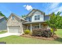 Attractive two-story home with brick and siding, a well-manicured lawn, and vibrant shrubbery at 5016 Brass Ct # 195, Locust Grove, GA 30248
