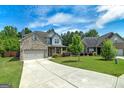 Inviting home featuring a brick facade, well-kept lawn, and a long driveway at 5016 Brass Ct # 195, Locust Grove, GA 30248