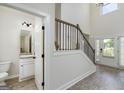 Open entryway with wood-look floors, a staircase with iron spindles, and a view into a half bath at 5016 Brass Ct, Locust Grove, GA 30248