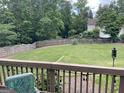 Spacious backyard with a wooden fence, seen from a deck with string lights at 840 Yosemite Dr, Suwanee, GA 30024