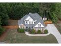 Stunning aerial view of a two-story home with brick and siding, lush landscaping, fenced yard, and a driveway at 150 Murphy Creek Ln, Fayetteville, GA 30215