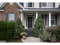 Inviting front entrance with a dark front door, decorative wreath, manicured shrubbery, and a welcoming porch at 150 Murphy Creek Ln, Fayetteville, GA 30215