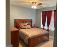 Bedroom with carpet, ceiling fan, and window with red curtains at 565 Miles Ct, Locust Grove, GA 30248