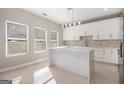 Modern kitchen with white cabinets, marble countertops, and large center island at 7428 Mockingbird Trl, Riverdale, GA 30274