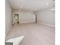 Spacious living room with light wood floors, recessed lighting, and elegant chandelier, perfect for entertaining at 7428 Mockingbird Trl, Riverdale, GA 30274