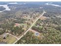 Aerial view of the property, showing its location near a lake and surrounded by dense trees at 3911 Peeksville Rd, Locust Grove, GA 30248