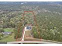 Aerial view of a home and property, surrounded by trees and a red line showing the property line at 3911 Peeksville Rd, Locust Grove, GA 30248