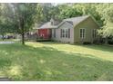 Exterior view of house with a large lawn, trees, and charming front porch at 714 Yates Rd, Bowdon, GA 30108