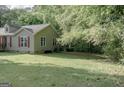Exterior view of a house with an expansive lawn, trees, and inviting side porch at 714 Yates Rd, Bowdon, GA 30108