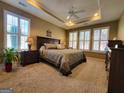Inviting main bedroom features tray ceilings, neutral carpeting, plantation shutters, and ample natural light at 511 Bonneset Ct, Canton, GA 30114