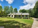 Charming single-story home with a well-manicured lawn and mature landscaping at 350 Lakeview Dr, Brooks, GA 30205
