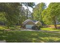 Charming brick home with attached garage and large driveway, surrounded by lush greenery and mature trees at 4333 Deer Ridge Ct, Lilburn, GA 30047