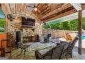 Inviting outdoor living space with stone fireplace, ceiling fan, and comfortable seating area with a view of the pool at 3313 Henson Ln, Stockbridge, GA 30281