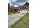 A concrete driveway leads to a brick single-story home with an attached two-car garage at 201 Summerford Pl, Stockbridge, GA 30281