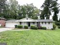 Single story home features a well kept lawn, painted brick and a cozy front porch at 4487 Greenleaf Sw Cir, Atlanta, GA 30331