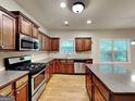 Well-lit kitchen featuring stainless steel appliances, wooden cabinets, and granite countertops at 330 Bentleigh Station Dr, Acworth, GA 30101