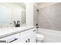 Clean bathroom with granite vanity, tub with tile surround, and black fixtures at 3423 Arabian Farm Ln, Dacula, GA 30019