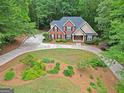 Aerial view of a lovely brick home showcasing circular driveway and lush greenery at 30 Joe Lee Dr, Sharpsburg, GA 30277