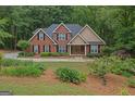 Charming brick home with black shutters, lush landscaping, and a welcoming front entrance at 30 Joe Lee Dr, Sharpsburg, GA 30277