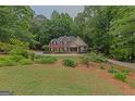 Beautiful brick home surrounded by mature trees and a well-manicured lawn at 30 Joe Lee Dr, Sharpsburg, GA 30277