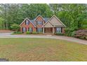 Beautiful home with a circular driveway, well-manicured lawn, and mature trees at 30 Joe Lee Dr, Sharpsburg, GA 30277