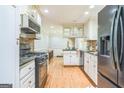 Functional kitchen featuring white cabinets, a black gas range, and stainless steel appliances at 2201 Valley Creek Cir, Snellville, GA 30078