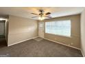 Bright living room featuring a ceiling fan, carpeted floors, and access to the front door at 6309 Wellington Way, Austell, GA 30106