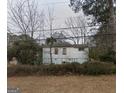 Quaint single-story home with peeling paint, surrounded by overgrown landscaping, offering a glimpse of potential at 2010 Mcafee Pl, Decatur, GA 30032