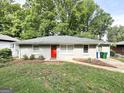 A charming home with a red door and lush green trees in the background at 2215 Rosewood Rd, Decatur, GA 30032