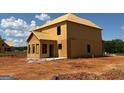 This is a two-story home in the framing stage of construction with a plywood exterior on a dirt lot at 252 Old Jackson Rd, Mcdonough, GA 30252