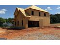 This is a two-story home in the framing stage of construction with a plywood exterior on a dirt lot at 252 Old Jackson Rd, Mcdonough, GA 30252