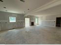 Bright, unfinished living room with two windows and door openings, presenting a spacious layout at 252 Old Jackson Rd, Mcdonough, GA 30252