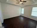 Spacious main bedroom featuring tray ceilings, neutral walls, and two large windows at 6372 Stonebridge Creek Ln, Lithonia, GA 30058