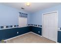 Cozy bedroom featuring blue walls, light carpet, and a double door closet at 421 Old Ivy Path, Mcdonough, GA 30253