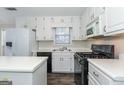 Bright kitchen featuring white cabinetry, stainless steel appliances, and wood-look flooring at 421 Old Ivy Path, Mcdonough, GA 30253