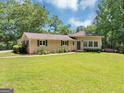 Beautifully maintained ranch home featuring a lush green lawn and mature trees providing shade at 4820 Yeager Rd, Douglasville, GA 30135