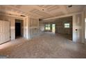 Unfinished living room with ample natural light and access to an adjacent room at 1936 King Mill Rd, Mcdonough, GA 30252