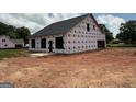 The exterior of the new house under construction shows the framing and roof at 1926 King Mill Rd, Mcdonough, GA 30252