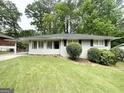 Charming home boasts a well-manicured lawn and inviting curb appeal with a side carport at 2651 Lois Se Ln, Atlanta, GA 30315