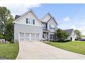Charming two-story home featuring light gray siding, a well-manicured lawn, and a two-car garage at 1016 Buckeye Ln, Villa Rica, GA 30180