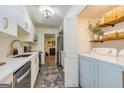 Bright kitchen with white cabinets, stainless appliances, and a convenient laundry area at 65 Cobblestone Crk, Peachtree City, GA 30269