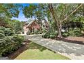 Elegant brick home with a circular driveway, lush landscaping, and a serene setting at 106 Hidden Springs Ln, Peachtree City, GA 30269