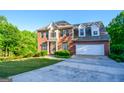 Beautiful two-story brick home with manicured lawn, attached two-car garage, and classic architectural details at 155 Cottage Cir, Fayetteville, GA 30215