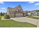 A well-maintained single Gathering home with a two-car garage, lush lawn, and brick facade at 500 Cottonwood Cir, Peachtree City, GA 30269
