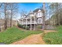 Charming two-story home with stone accents, a covered front porch, and a lush, verdant lawn at 600 Lake Overlook Dr, Canton, GA 30114