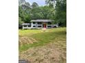 Lovely front exterior with green lawn, mature trees and a charming brick home at 3132 Riders Trl, Decatur, GA 30034