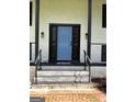Close-up of a light blue front door with black trim and brick steps leading up to it at 3132 Riders Trl, Decatur, GA 30034